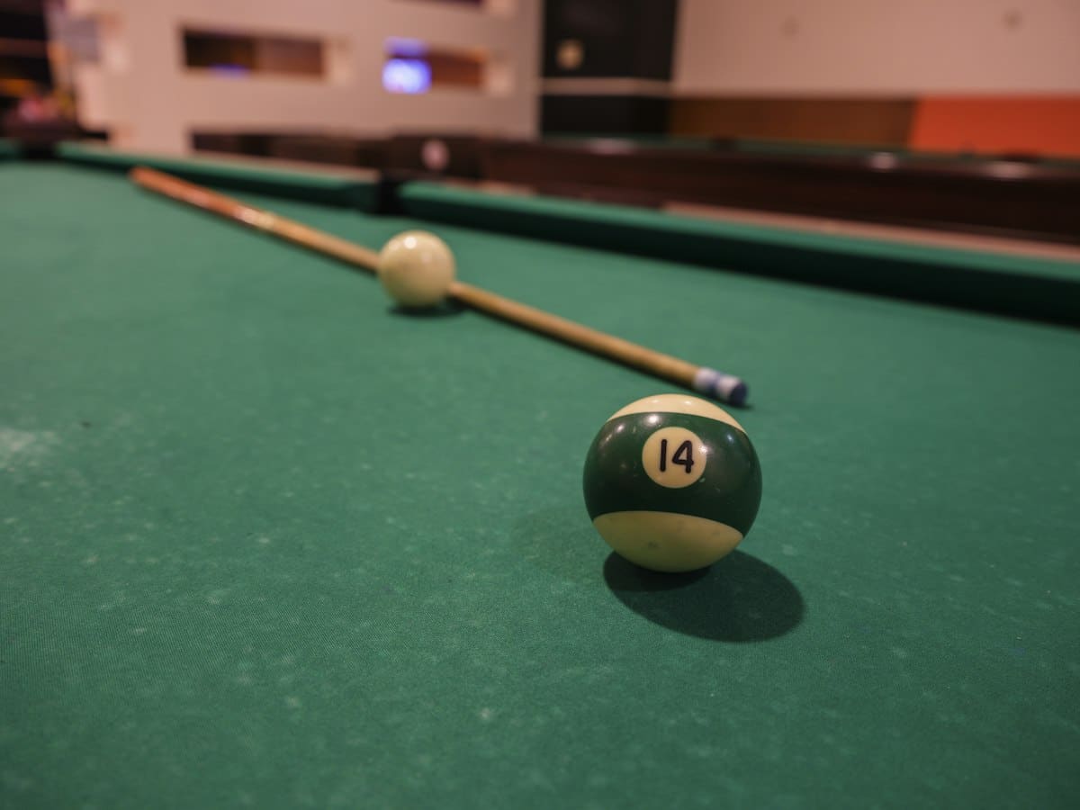 Poolbillardtisch mit Kugeln und Queue als Symbolbild für Effet